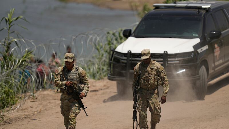 Guardias patrullan mientras los trabajadores continúan desplegando grandes boyas que se...