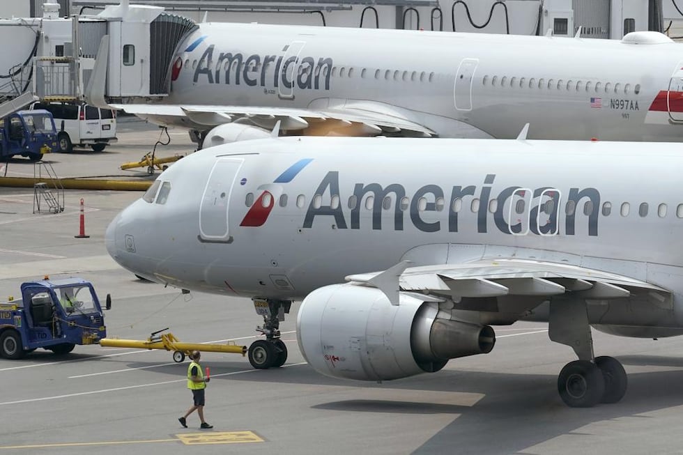 ARCHIVO - Jets de pasajeros de American Airlines preparan la partida desde una terminal del...